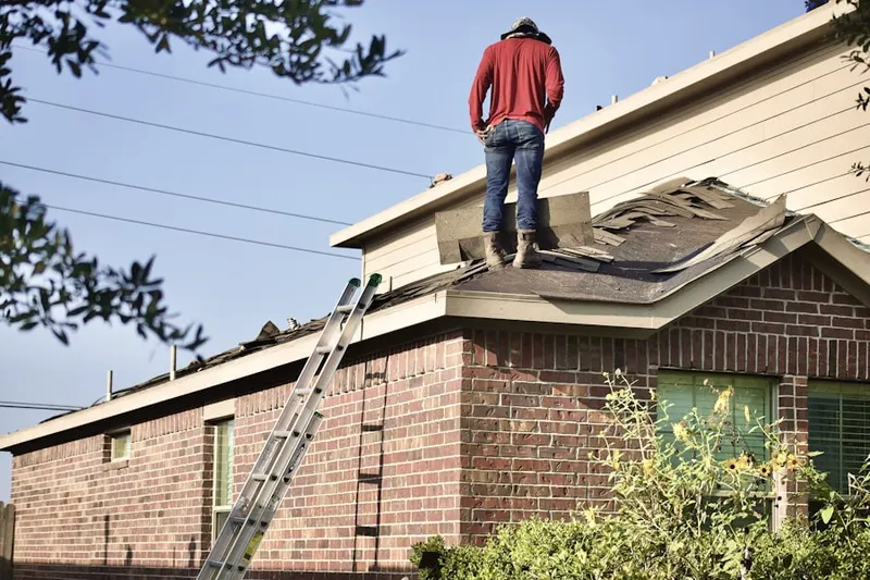Professional roofer working on a residential roof in Aquebogue